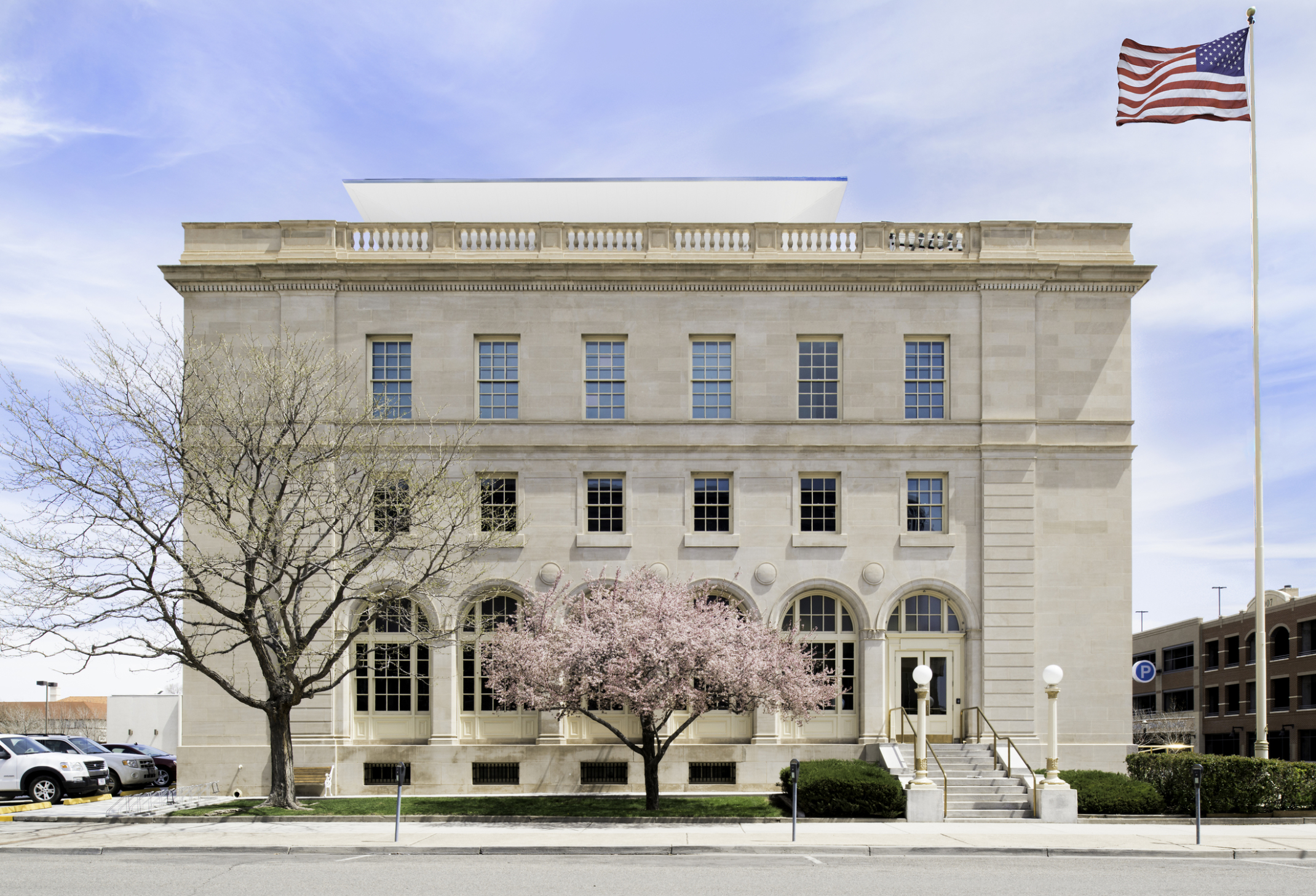 the exterior of the wayne aspinall federal building with a pink flowering tree in the foreground