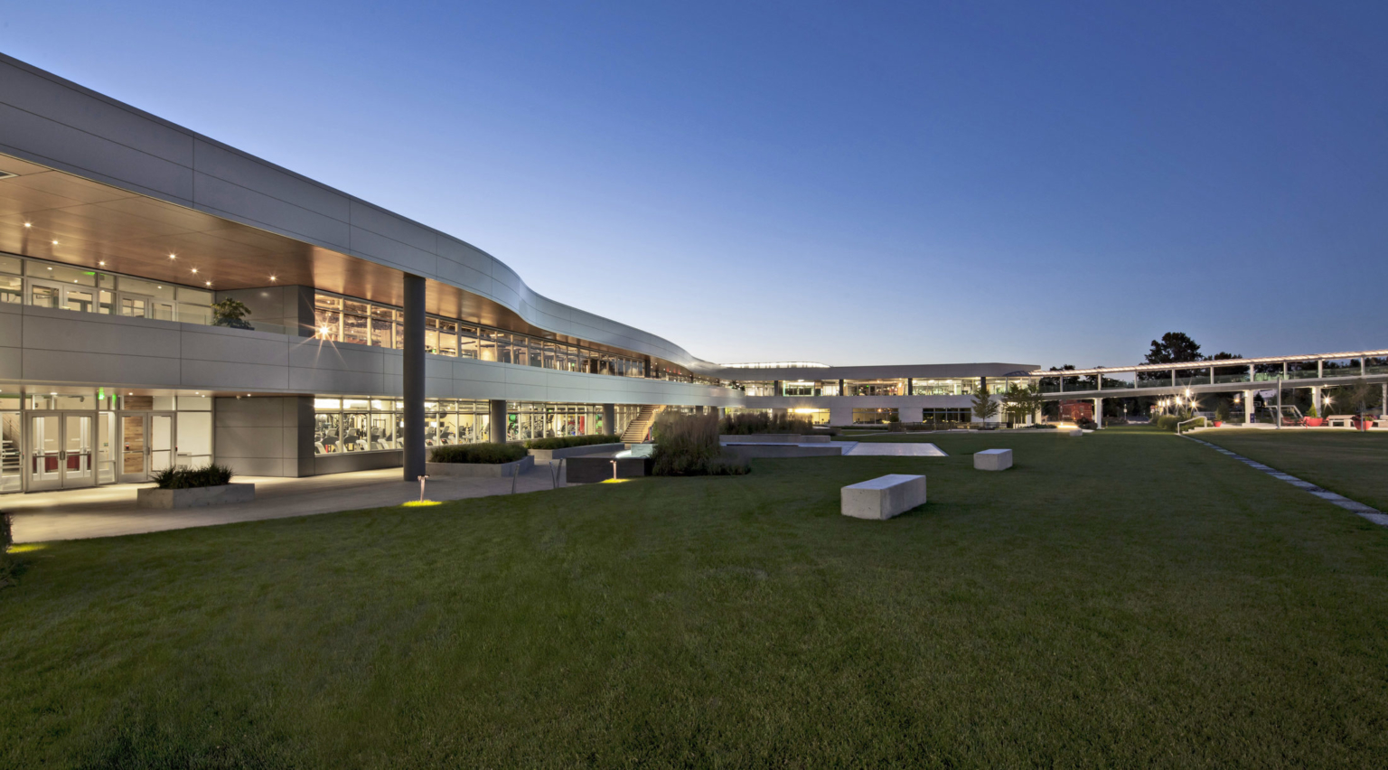 curvaceous two story campus building illuminated at dusk