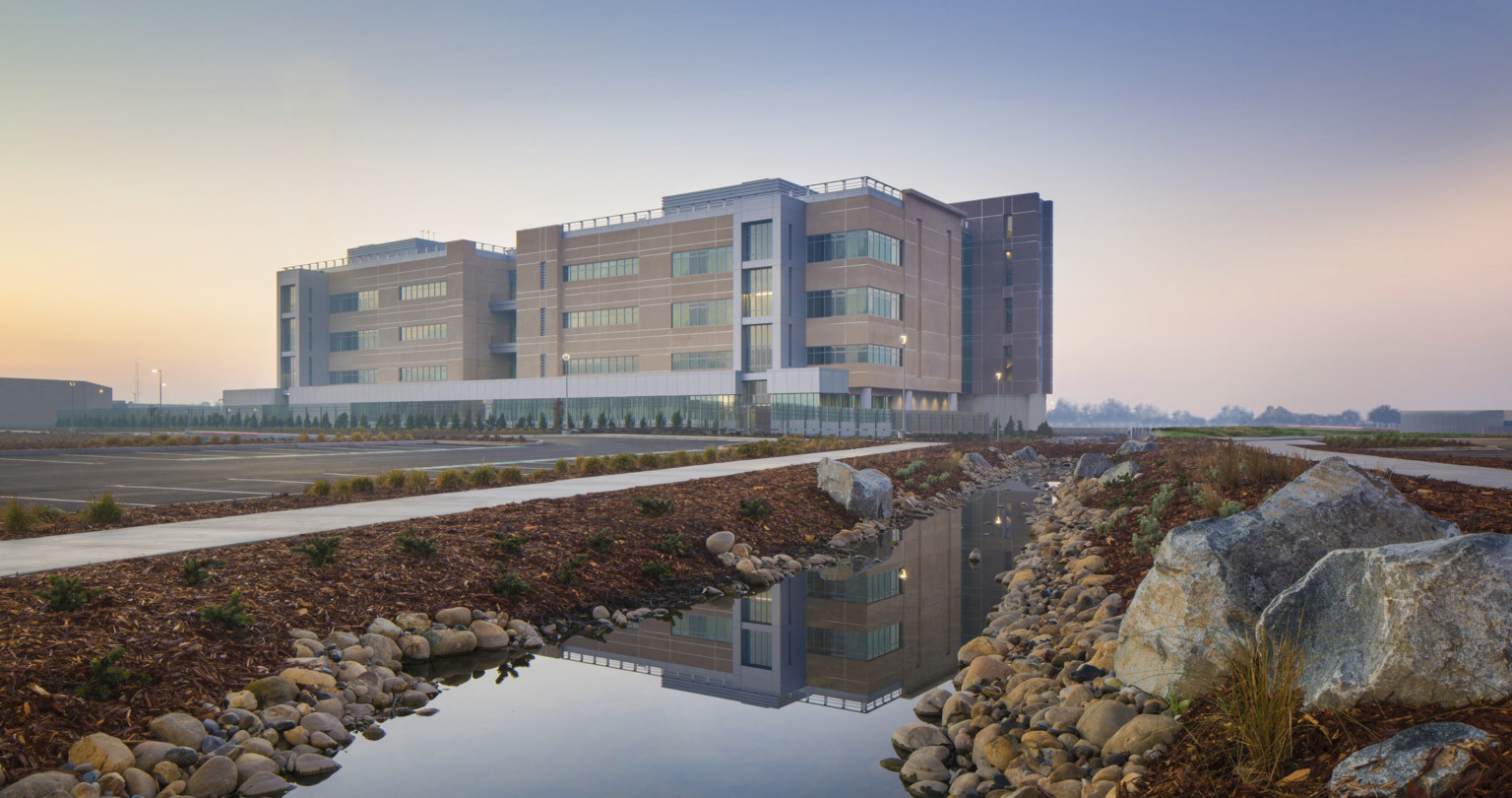 Kings County Courthouse exterior view. 4 story building with stone and glass facade from across parking, reflected in water Kings County Courthouse exterior view. 4 story building with stone and glass facade from across parking, reflected in water