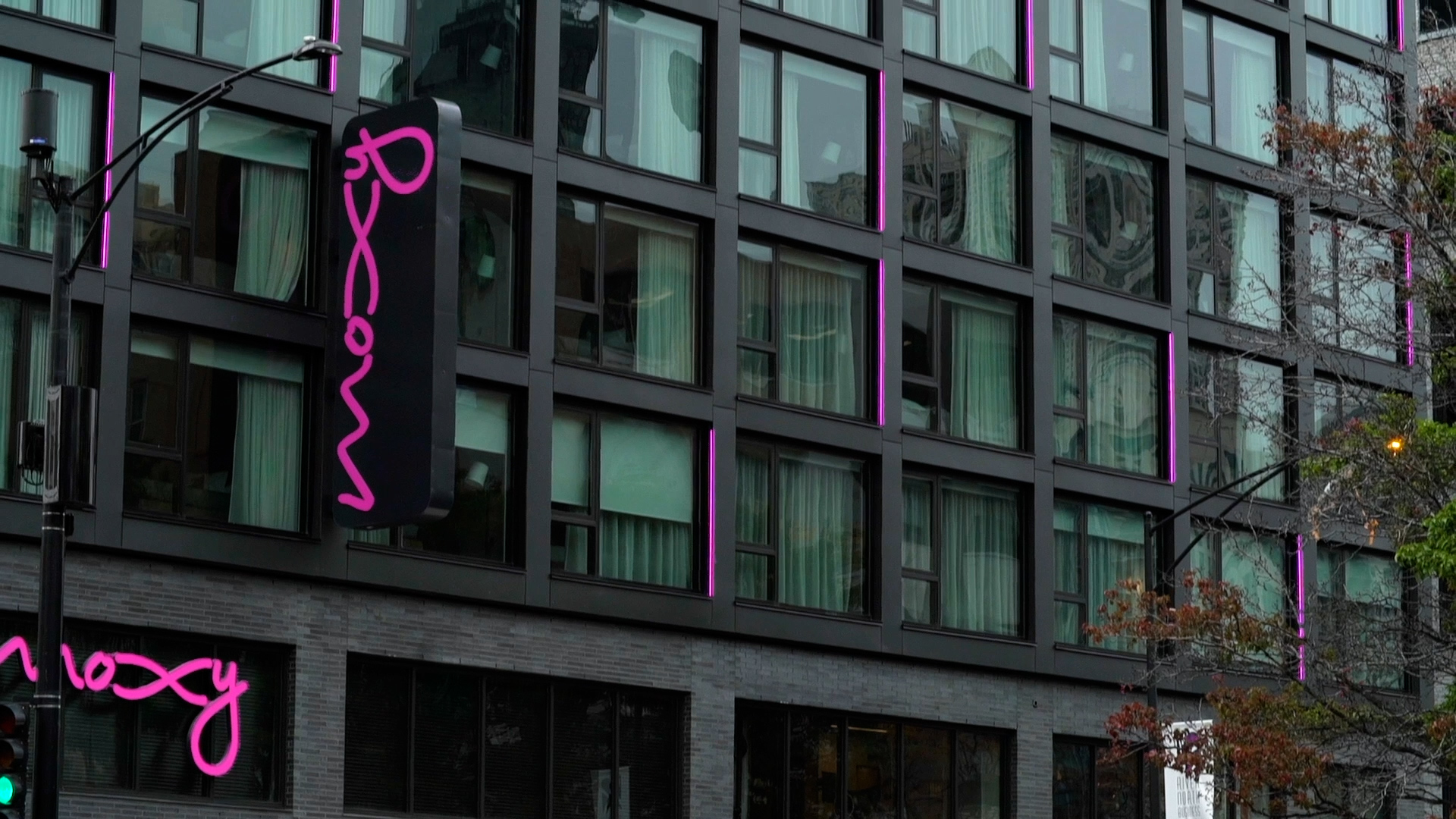 close up of a modern architecture facade with metal cladding and purple accents with Moxy written on signage close up of a modern architecture facade with metal cladding and purple accents with Moxy written on signage