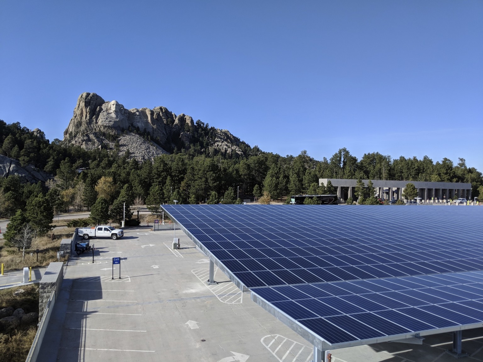 Solar canopy in parking lot in front of Mount Rushmore with trees in between