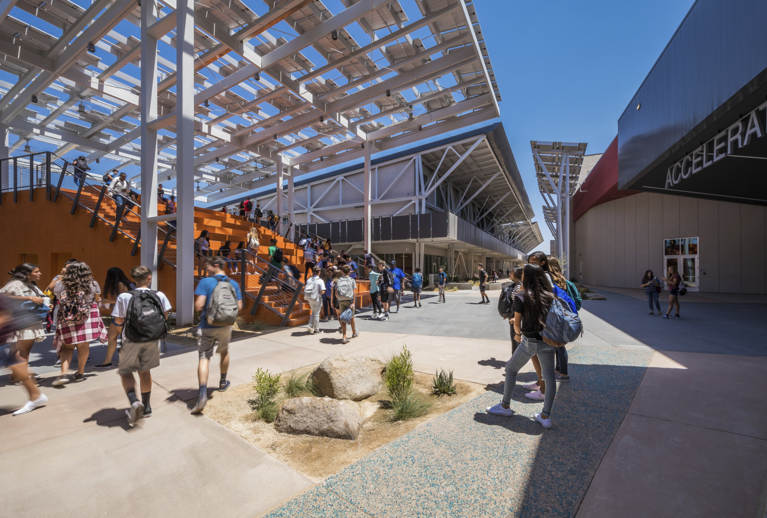 At the front of a walkway between buildings is a large orange partially covered staircase At the front of a walkway between buildings is a large orange partially covered staircase