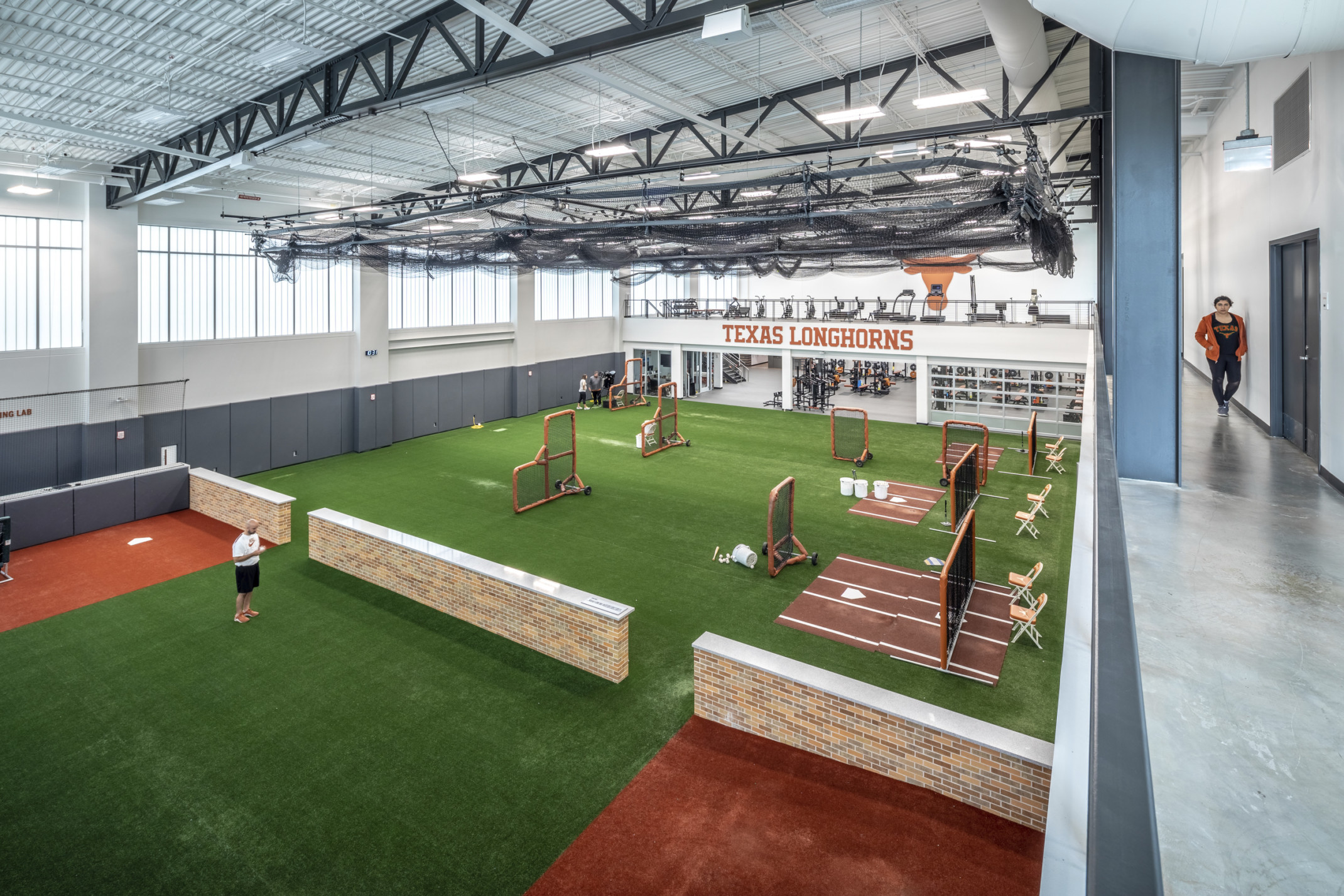 J. Dan Brown Baseball Development Facility at University of Texas interior training space. Turf floor in white room