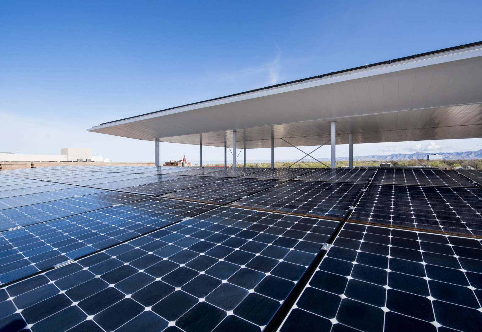 Rooftop solar array with mountains in the background Rooftop solar array with mountains in the background