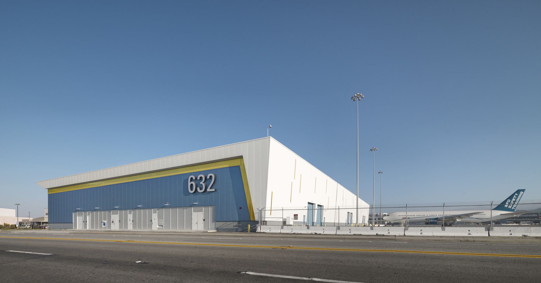 San Francisco International Airport’s West Field Cargo Facility, a blue yellow and white wrapped facade building beside plane