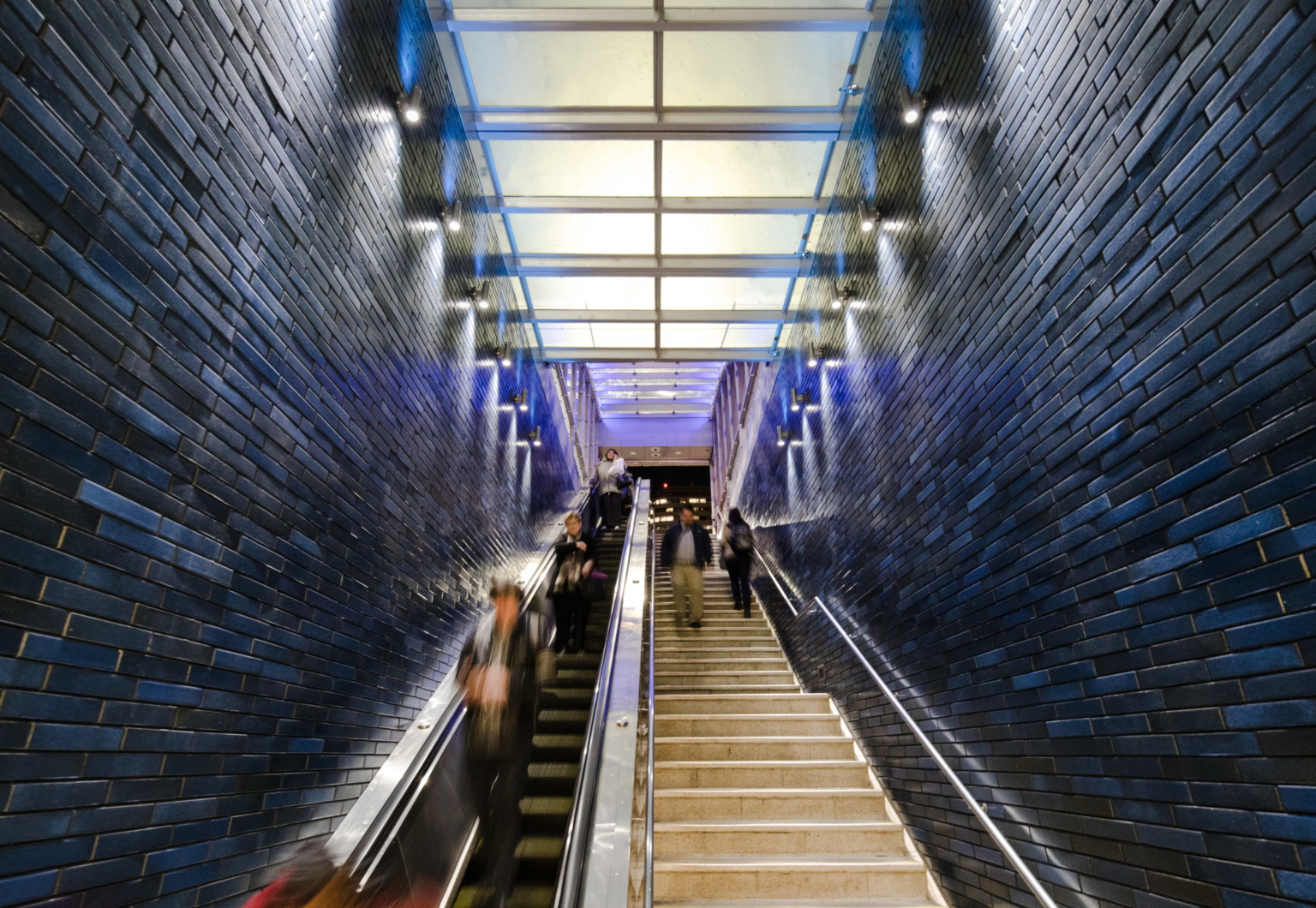 a glass canopy over a subterranean staircase with ceramic lined walls