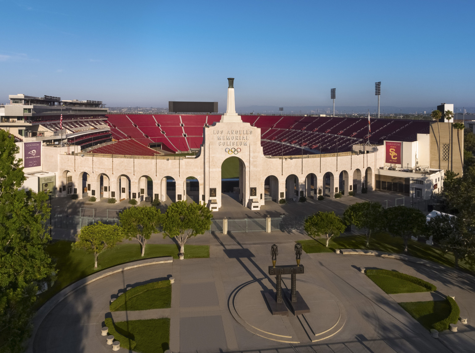 Front of stadium with Robert Graham sculpture Olympic Gateway at center of round plaza with greenery and arched entryway Front of stadium with Robert Graham sculpture Olympic Gateway at center of round plaza with greenery and arched entryway