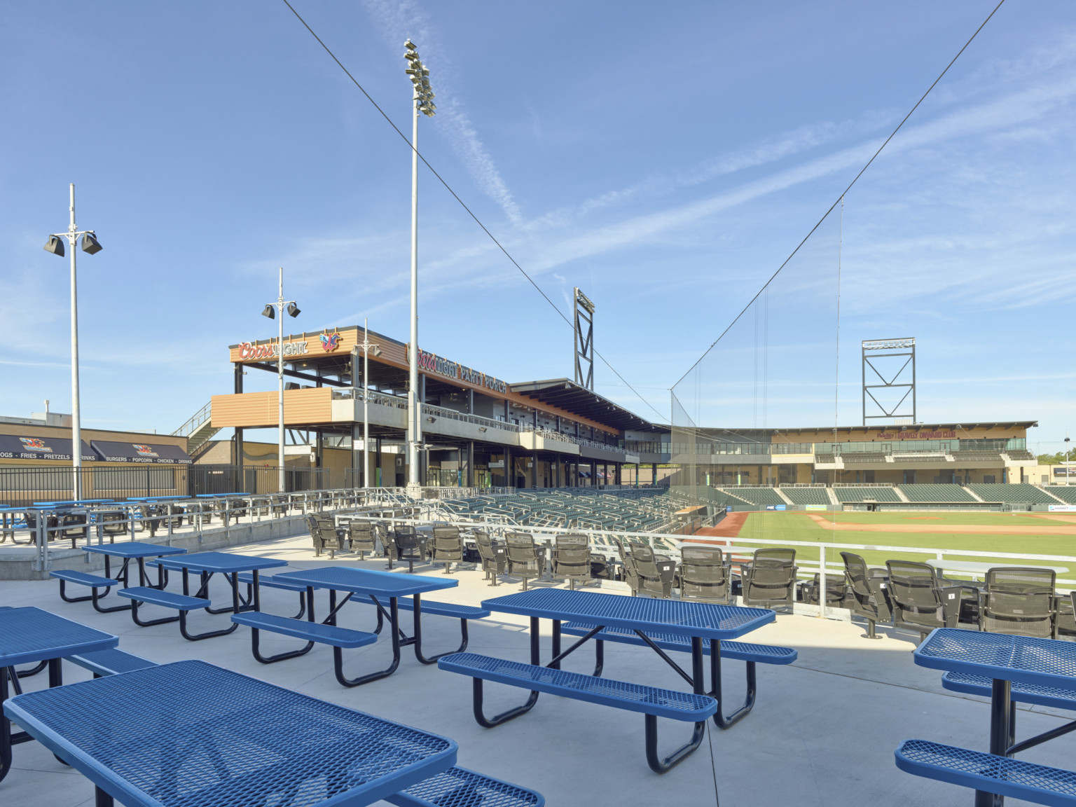 Seating in right field with alterative seating platform and mezzanine with picnic tables and swivel chairs along railing.