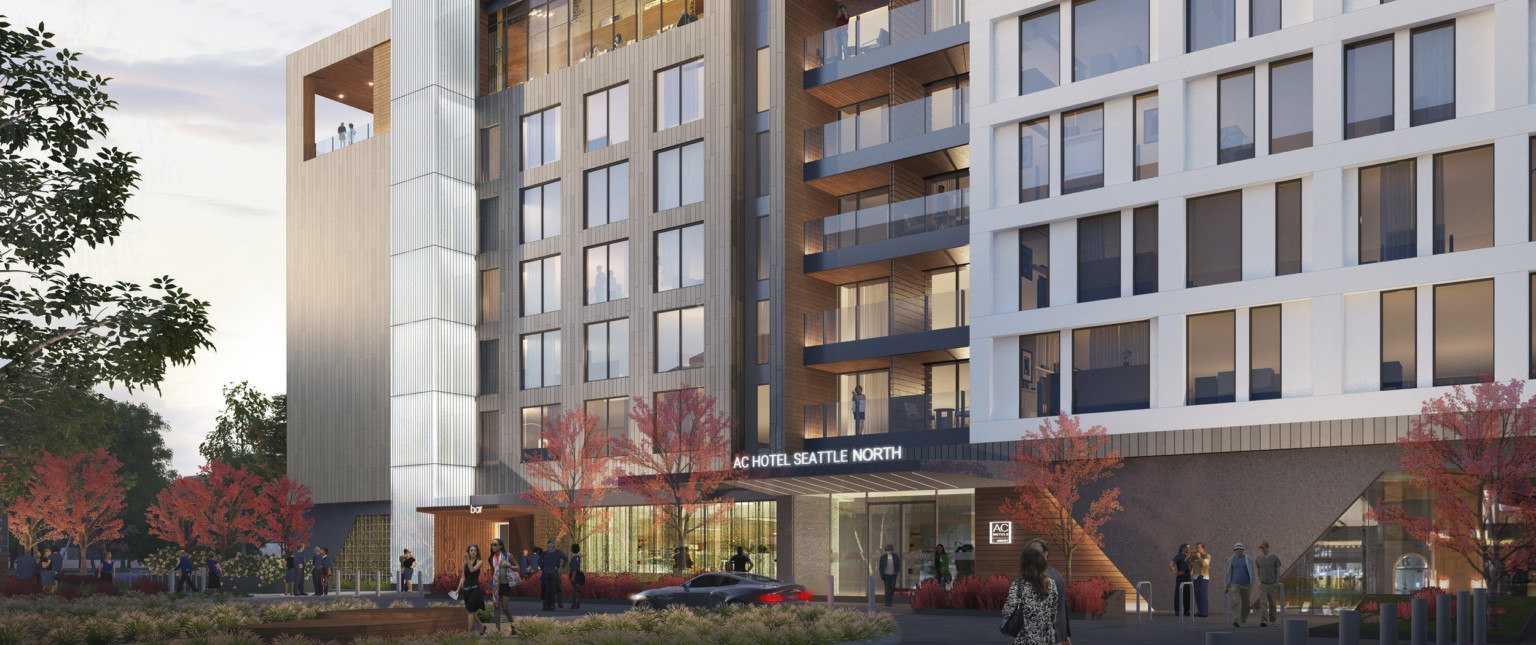 Exterior view of hotel entry with illuminated sign over doors and recessed balconies above Exterior view of hotel entry with illuminated sign over doors and recessed balconies above