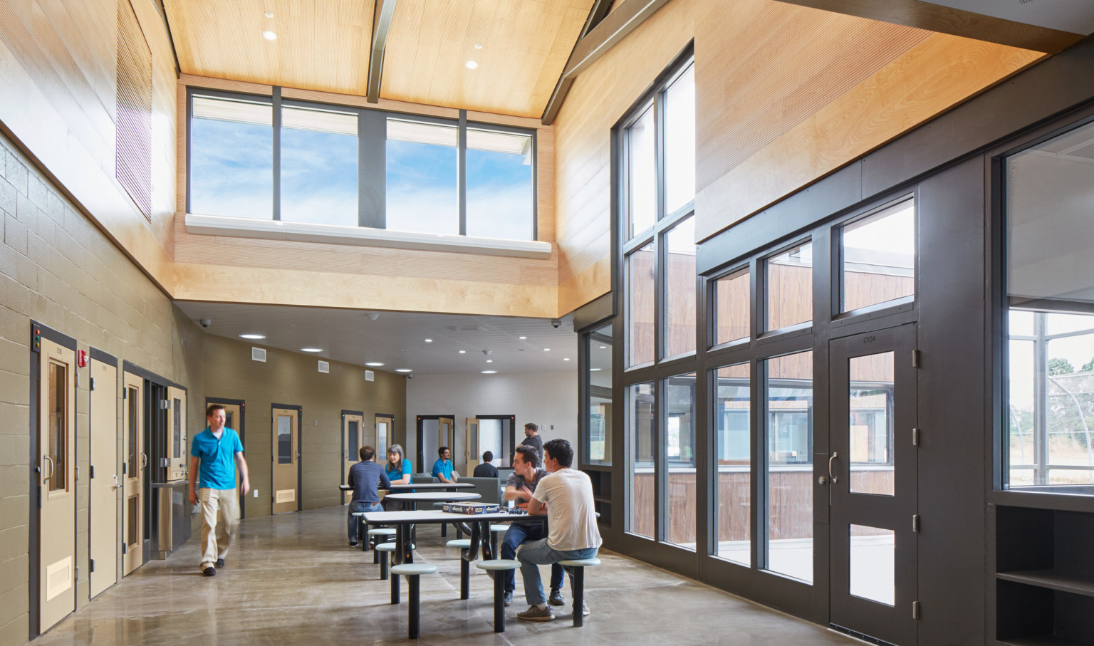 inside hall with large windows at Oregon Youth Authority MacLaren Campus with people gathered at tables