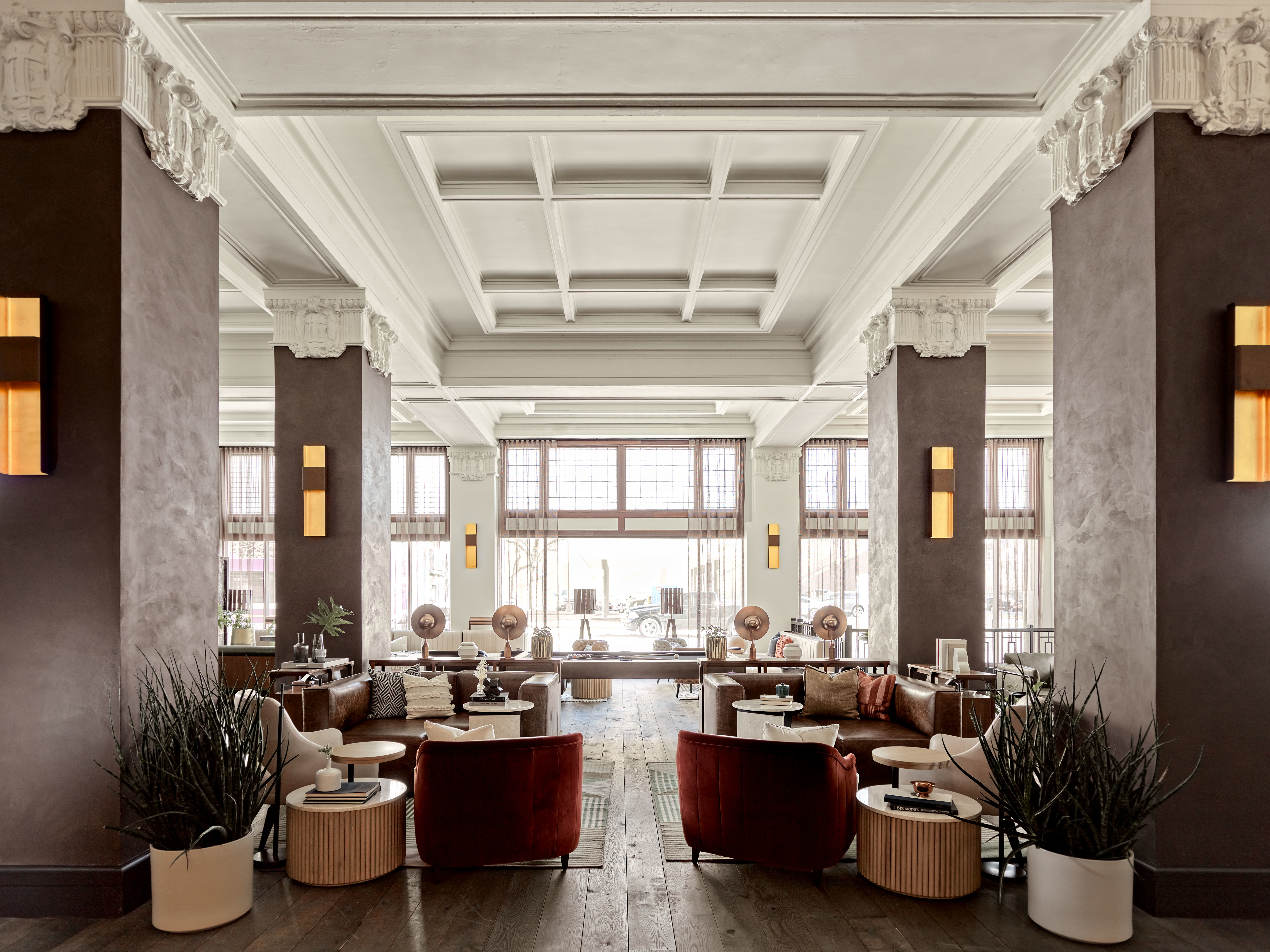 a lounge with upholstered seating under a white coffered ceiling and ornate plasterwork a lounge with upholstered seating under a white coffered ceiling and ornate plasterwork