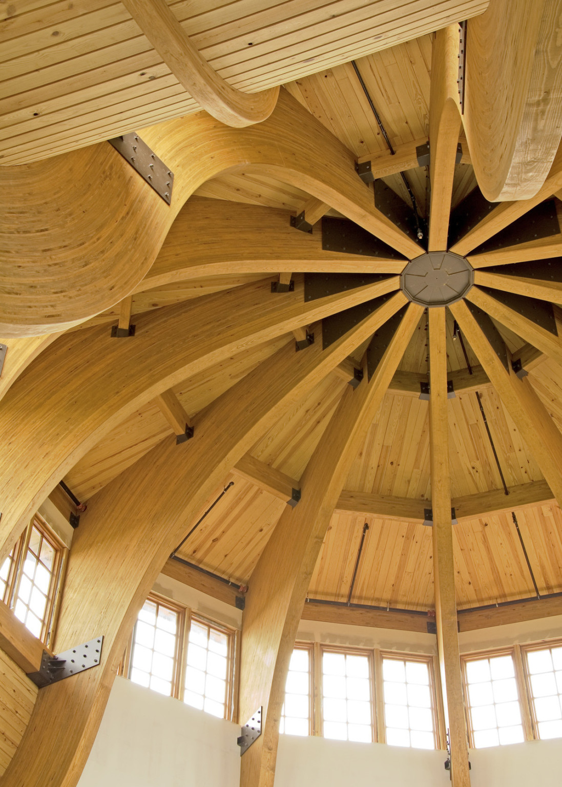 Sections of wood flow up the walls to meet in the cupola center circle