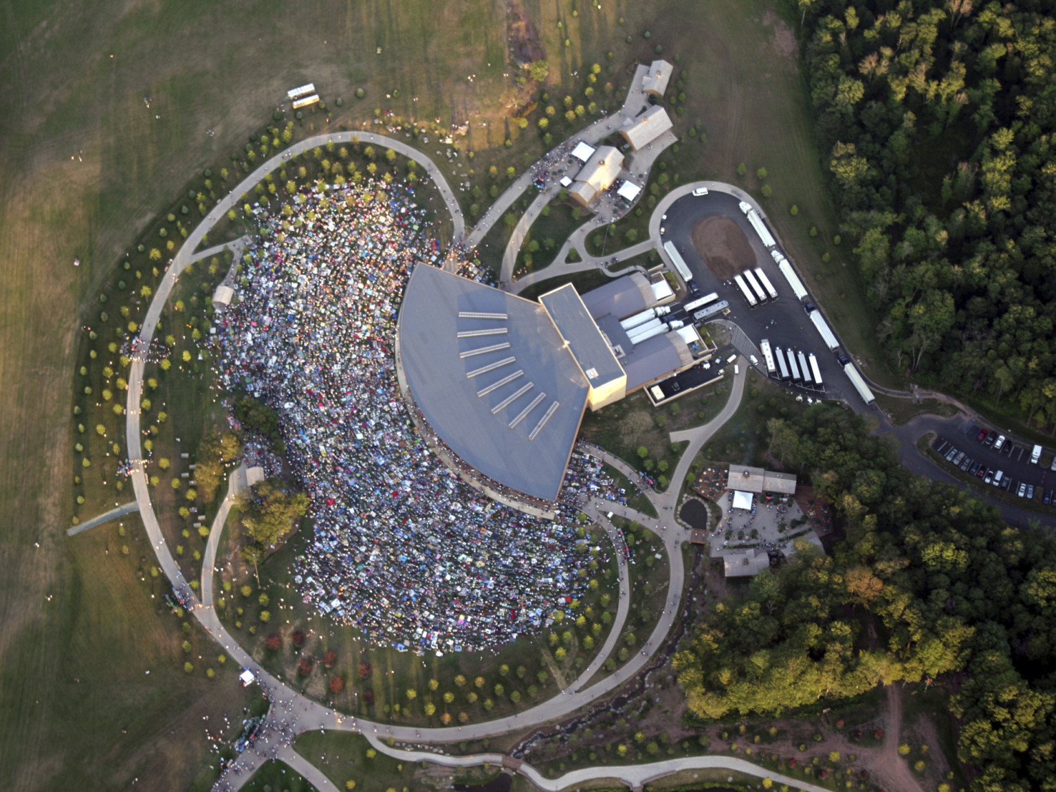 Aerial view of amphitheater with crowd in the surrounding field