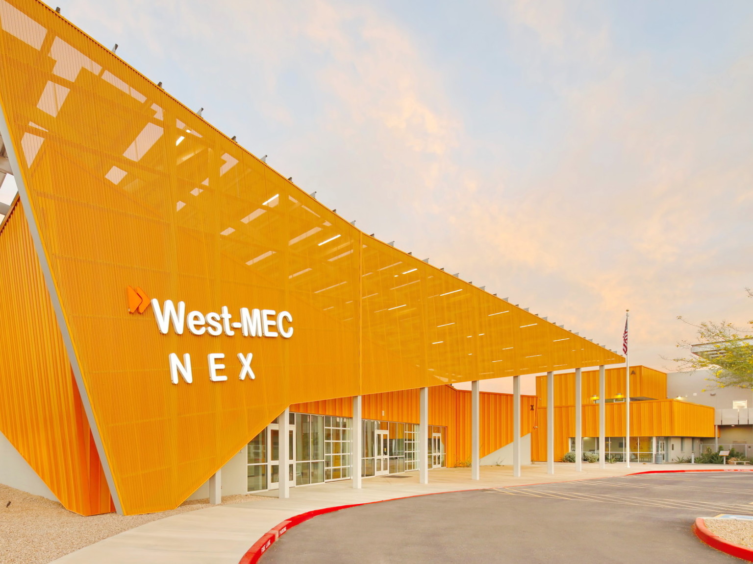 West-MEC NEX building at the Southwest Campus, an angular yellow building with sunscreen across the front with white sign