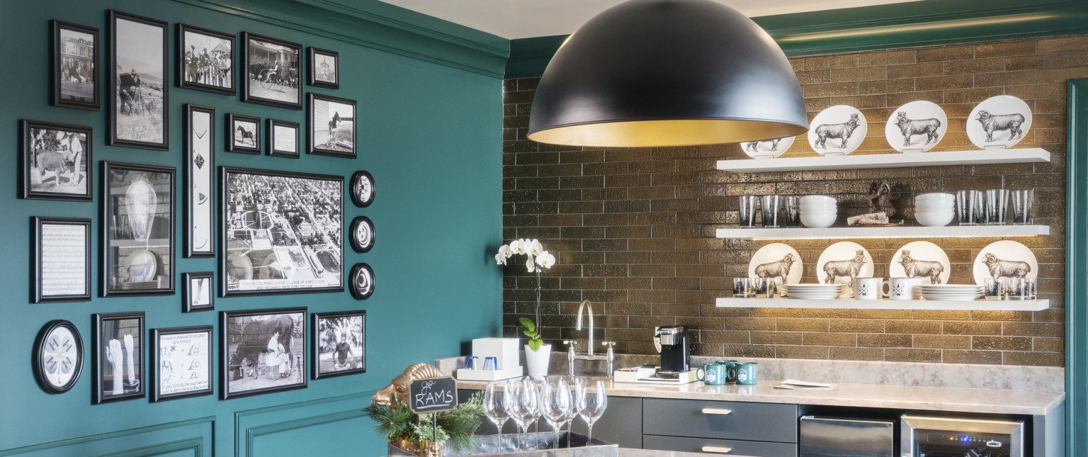 Green crown molding in room with left wall green and right wall brick over marble counter top with grey drawers