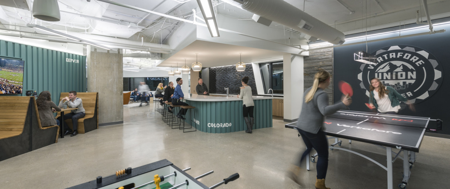 Vertafore Headquarters interior room with teal panel accents in space with counter, wood booths, and ping pong table Vertafore Headquarters interior room with teal panel accents in space with counter, wood booths, and ping pong table