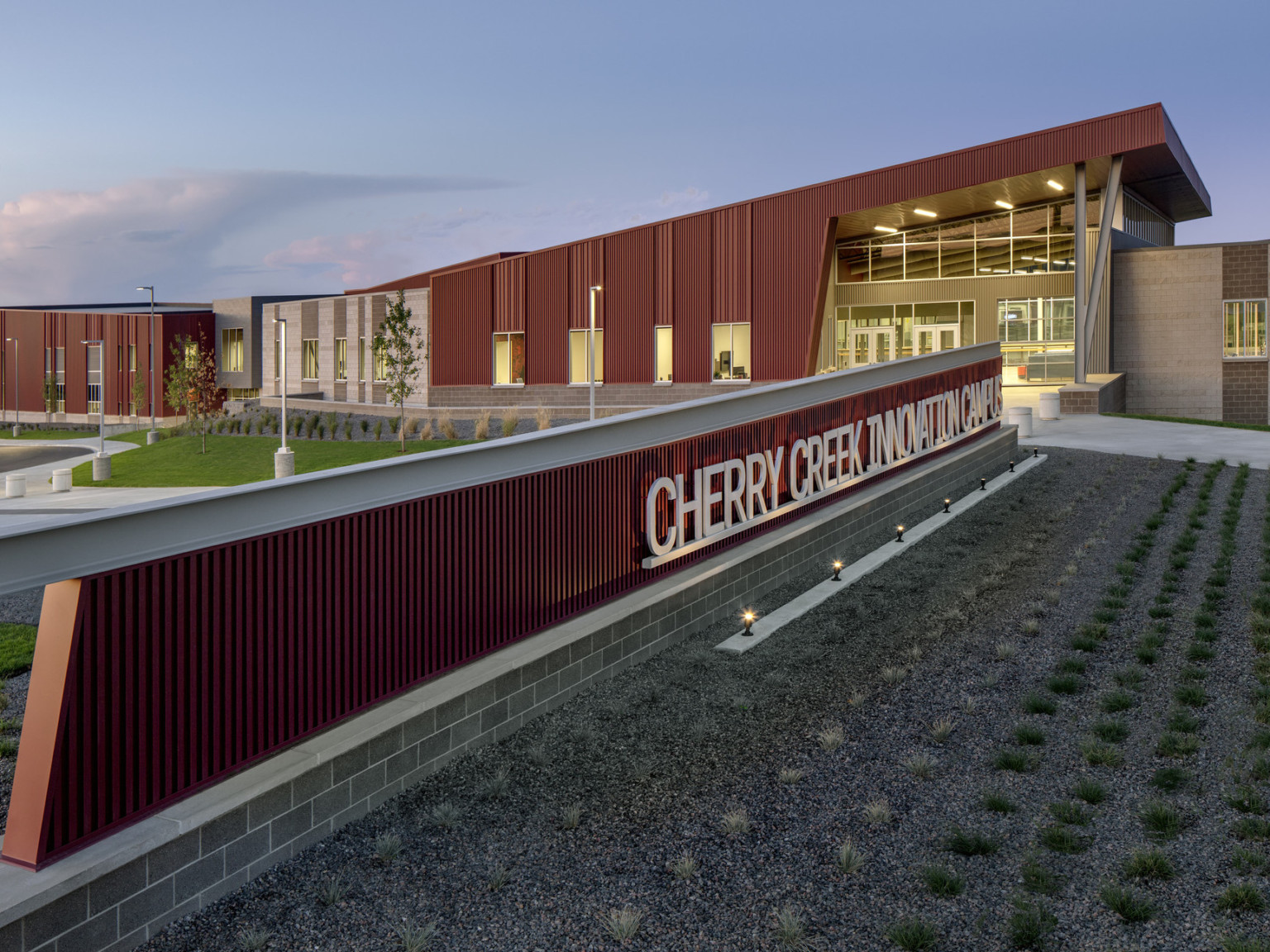Cherry Creek Career and Innovation Academy Campus entrance, a red panel building with long sign and canopy over glass entry