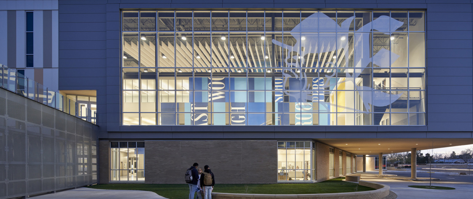Exterior view looking in to double height windows with translucent image of the Troop mascot. Inside is blue colorblock mural