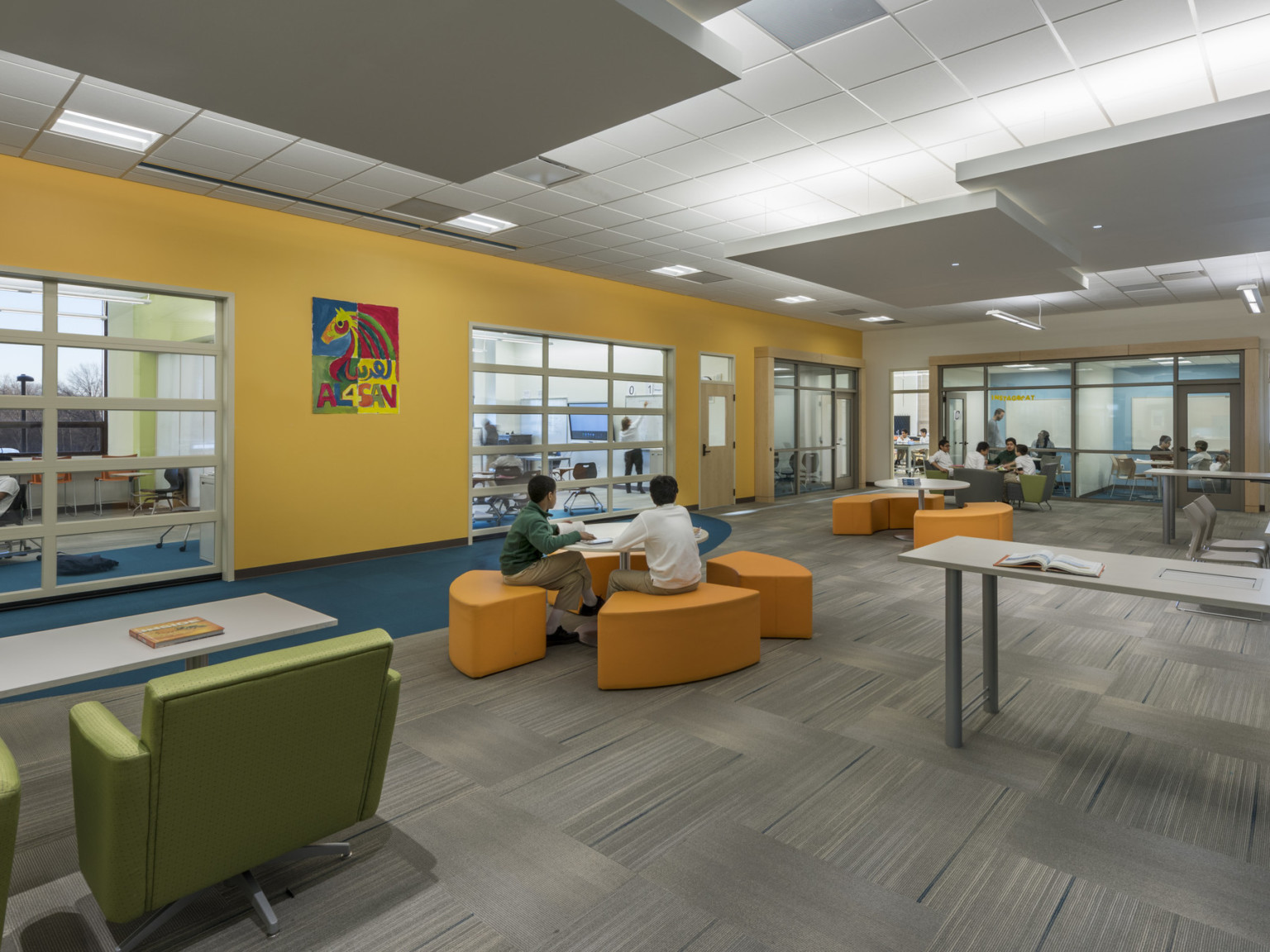 view of multiple classrooms with movable walls, writable surfaces, and flexible, colorful furniture