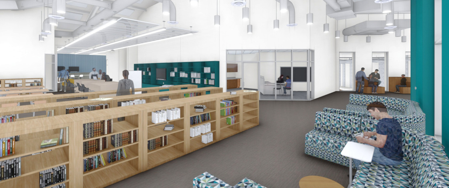 Multicolor U shaped couches in white library with half height wood bookshelves. Green shelf, left of glass walled room