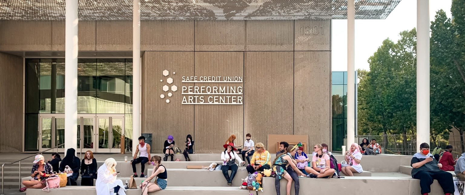 Concrete benches in front of entry providing gathering space under the shaded awning supported by white pillars Concrete benches in front of entry providing gathering space under the shaded awning supported by white pillars
