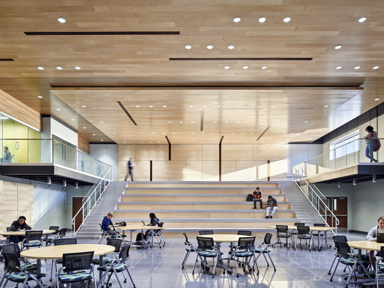 Learning staircase made from wood with ample lighting and learning pods on the side, dining area at the bottom at TCALC