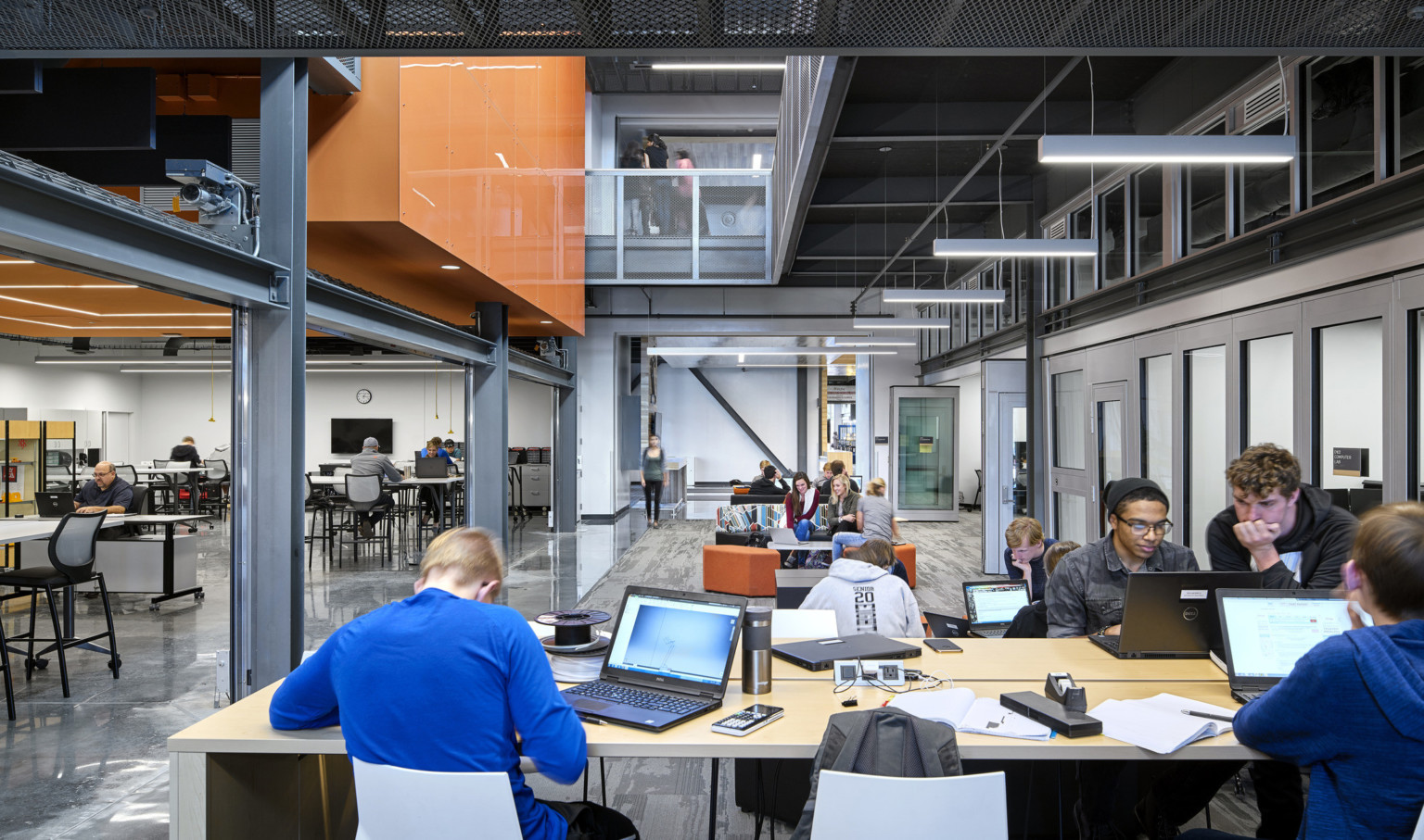 students collaborating in common space with exposed structure and views up to the second floor at the missouri innovation campus