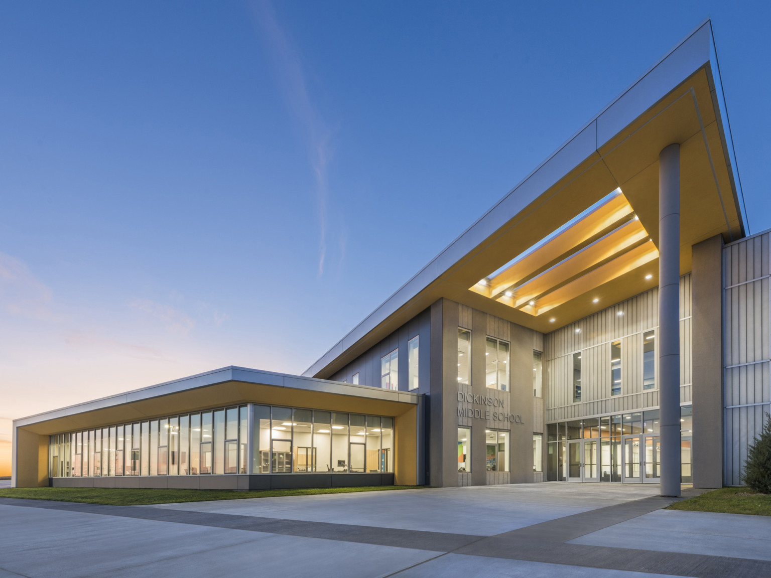 Dickinson Middle School, a grey panel building with skylight canopy and glass extension to left with wrapped facade