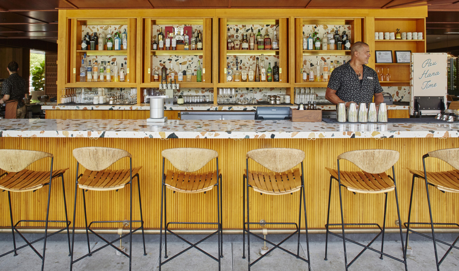 outdoor hotel bar with warm woods and speckled accents on grey floor, beach vibes, and full bar service for vacation outdoor hotel bar with warm woods and speckled accents on grey floor, beach vibes, and full bar service for vacation