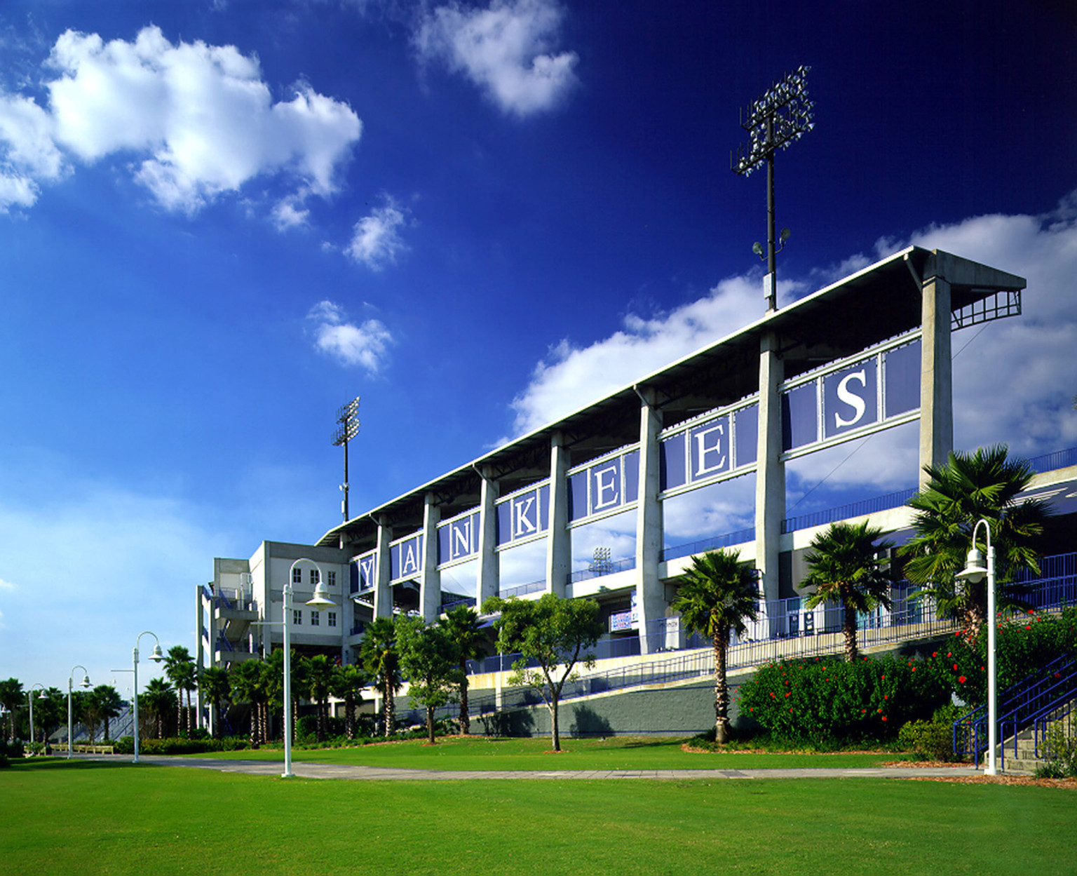 Exterior of Legends Field in Tampa, Florida. Lettering on blue panels of overhang spells Yankees, below a ramp leads to lawn