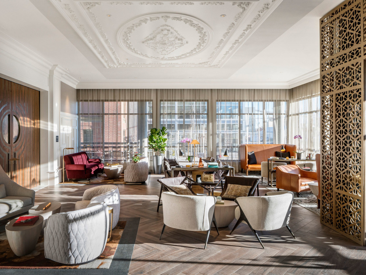 The Elizabeth Hotel, Autograph Collection lobby with white and orange seating, floor to ceiling windows, and crown molding