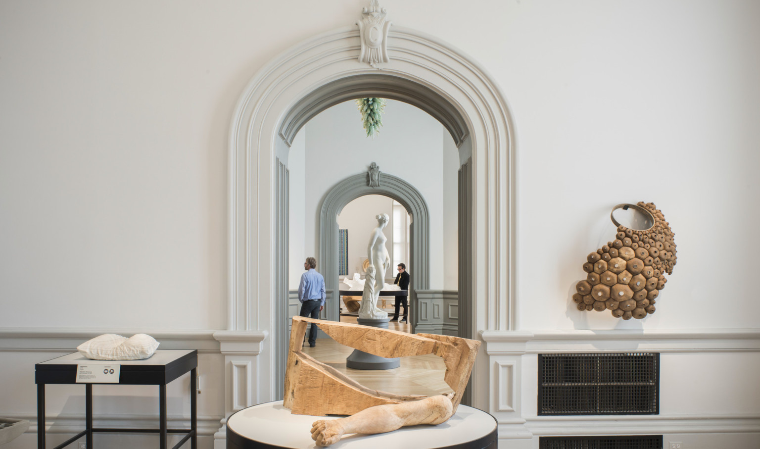 Abstract art object table display framed at back by arched door with crown molding at the renwick gallery