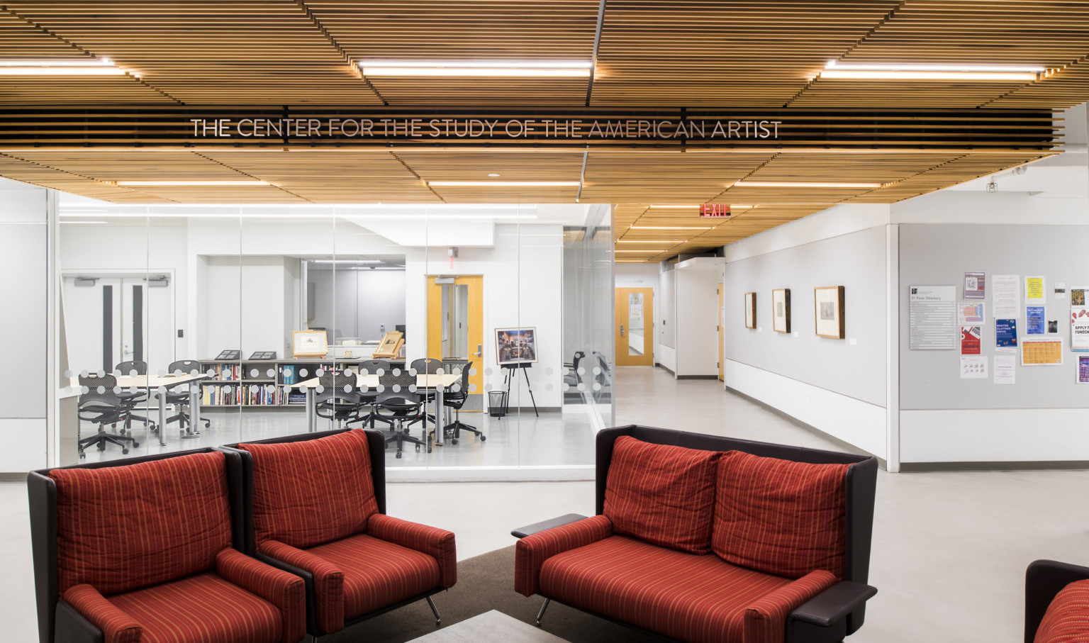 Red seats, wood slat ceiling, view of art storage via glass walls under The Center for the Study of the American Artist sign