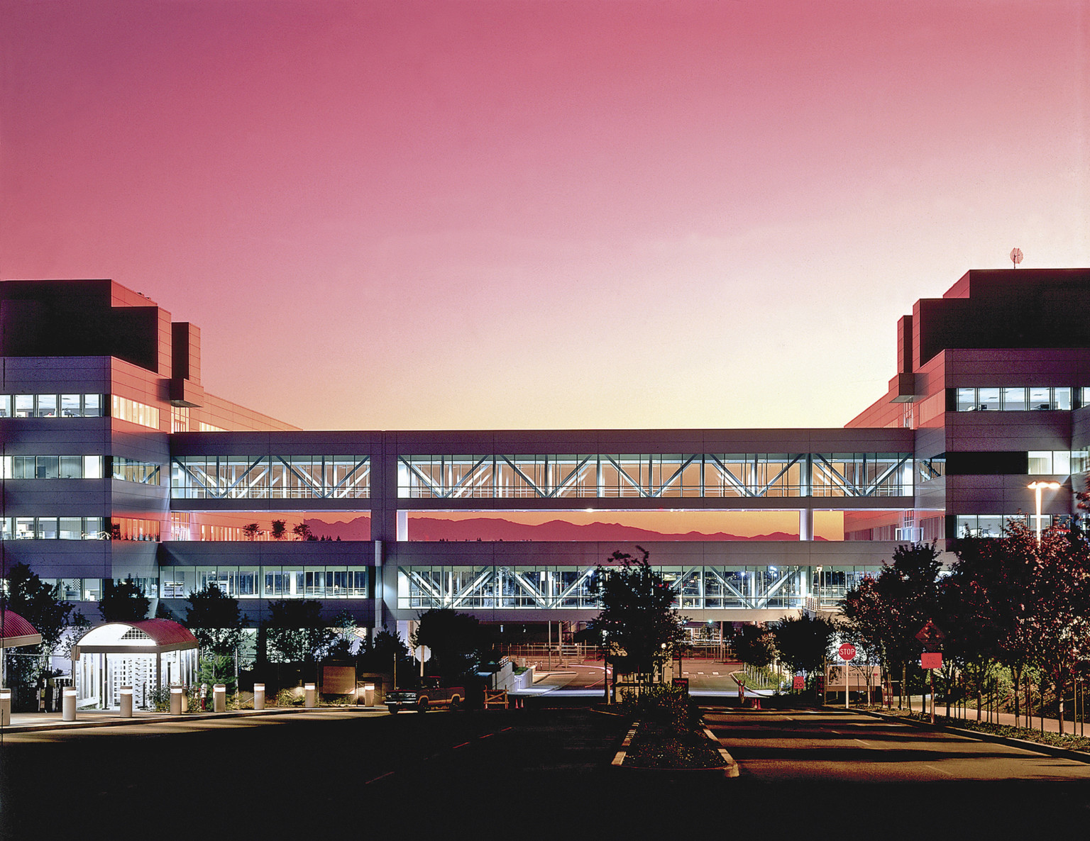 Boeing Everett 777 Office Complex at sunset with pink sky illuminating breezeway above two-way street Boeing Everett 777 Office Complex at sunset with pink sky illuminating breezeway above two-way street