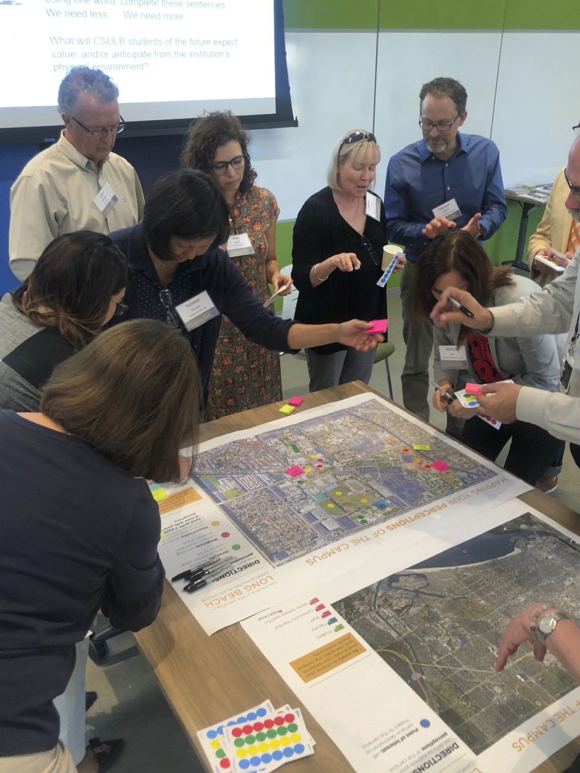 University stakeholders working together in a visioning session for the master plan looking at a campus map and making notes