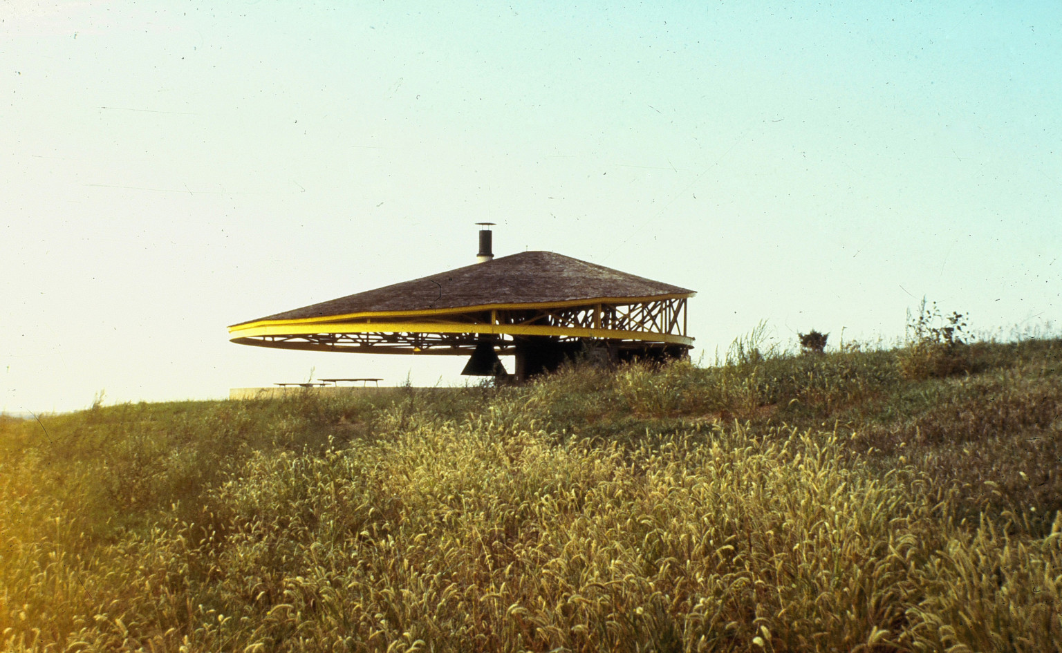 Black Elk-Neihardt Park pavilion, an asymmetrical yellow and black structure, in a grassy field in Nebraska