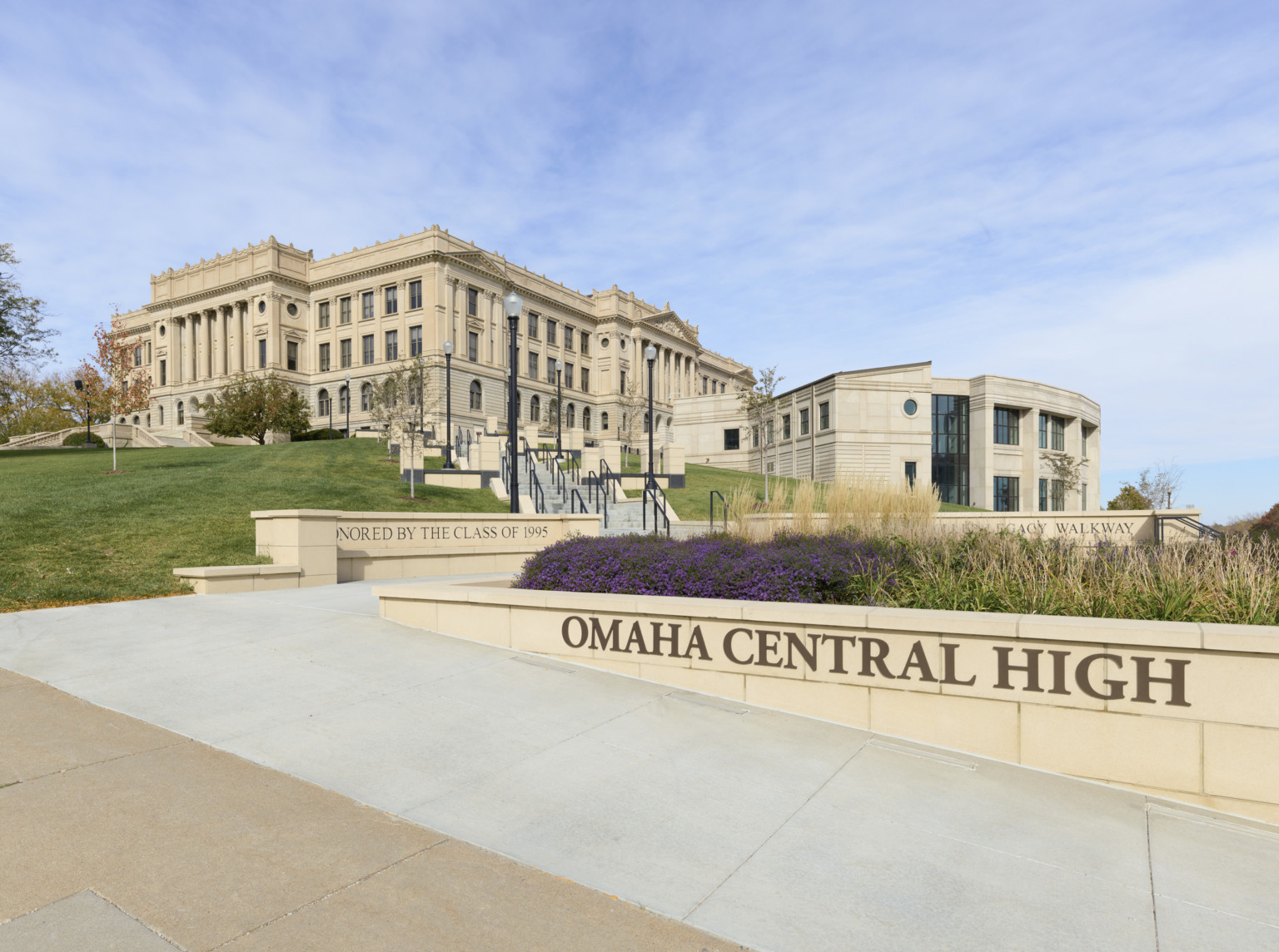 Exterior view of Omaha Central High School, a large 3 story beige stone building with new addition. Garden, front, behind sign Exterior view of Omaha Central High School, a large 3 story beige stone building with new addition. Garden, front, behind sign