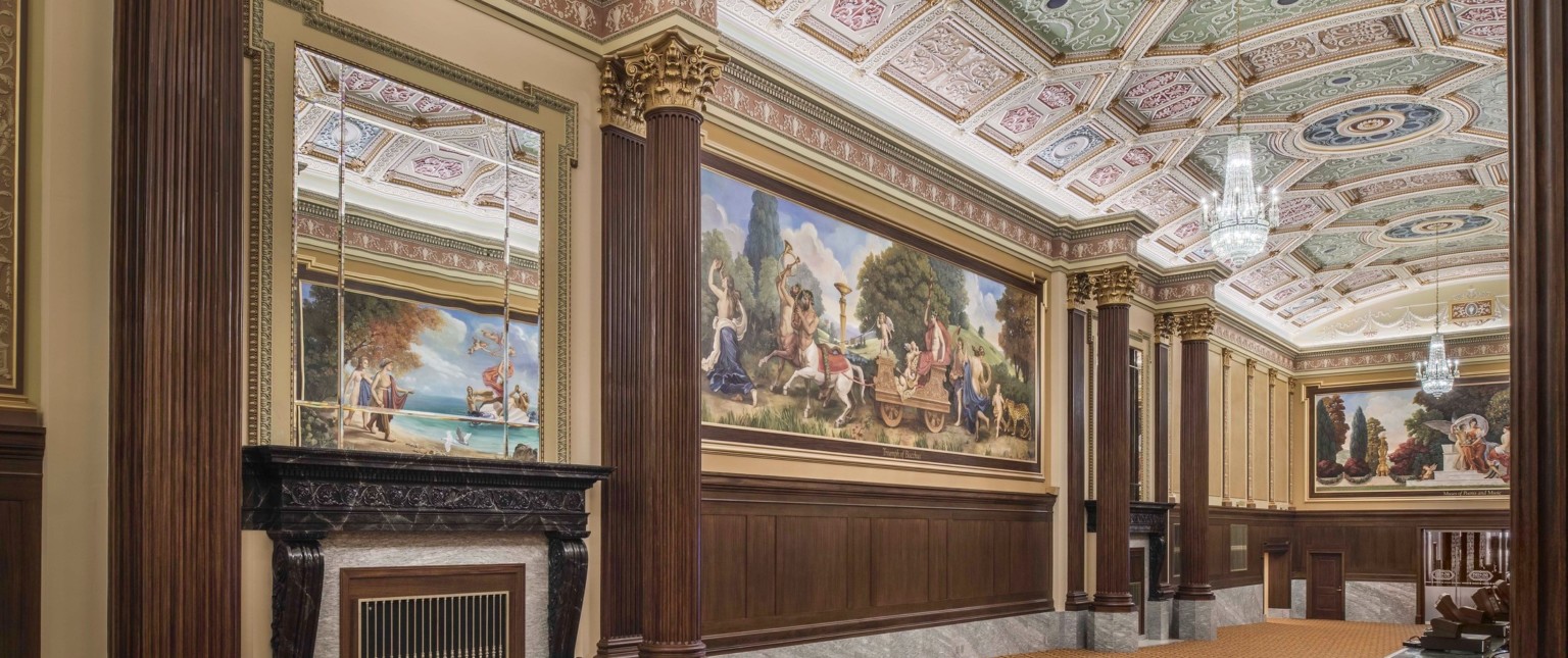 carpeted hallway with corinthian columns and colorful ceiling frescoes and large scale wall murals