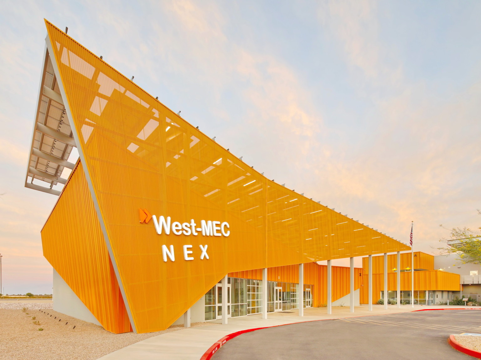 West-MEC NEX building at the Southwest Campus, an angular yellow building with sunscreen across the front with white sign