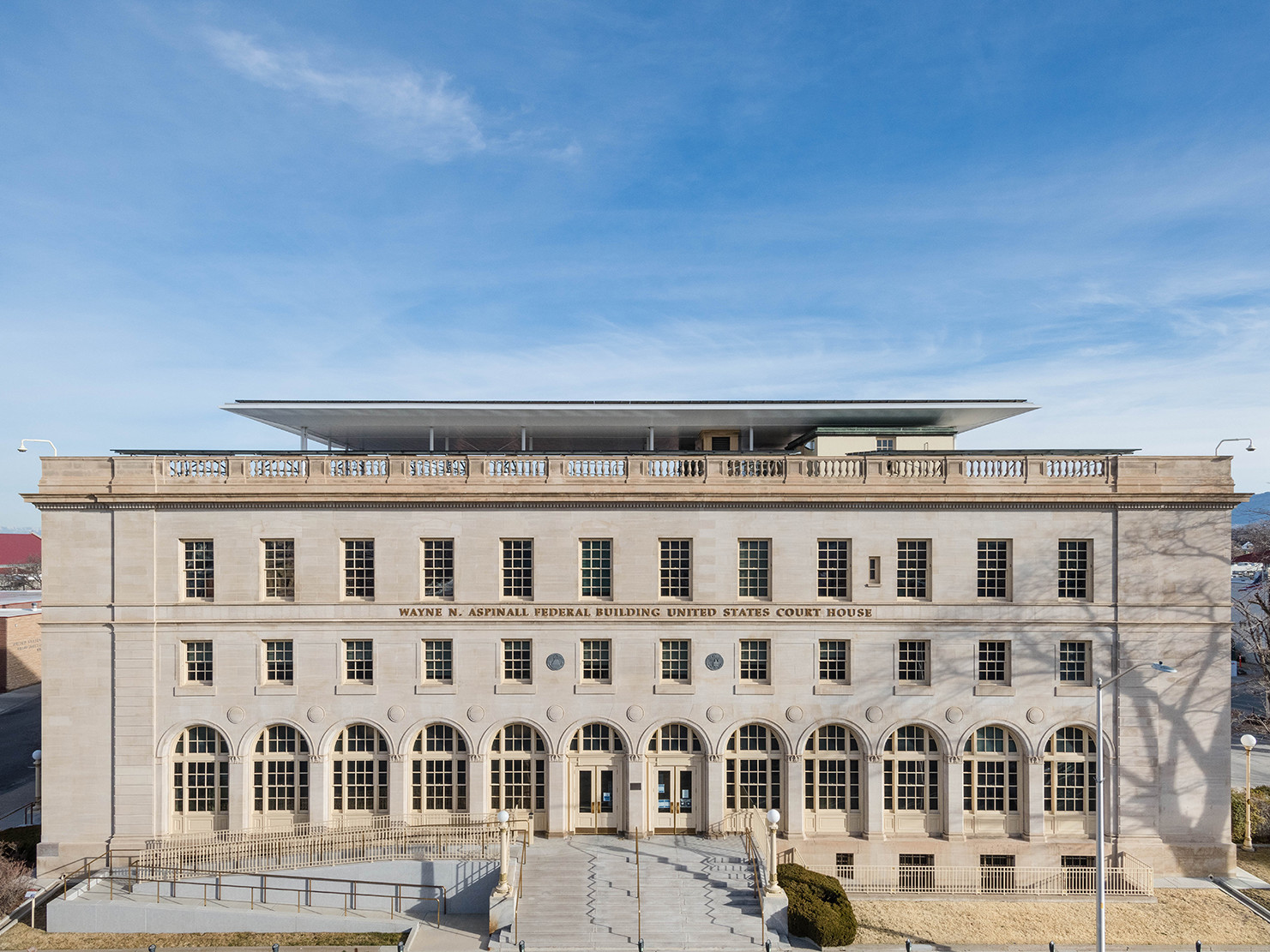 tan stone italianate renaissance building with arched ground level windows, parapet with baluster and squared column detail tan stone italianate renaissance building with arched ground level windows, parapet with baluster and squared column detail