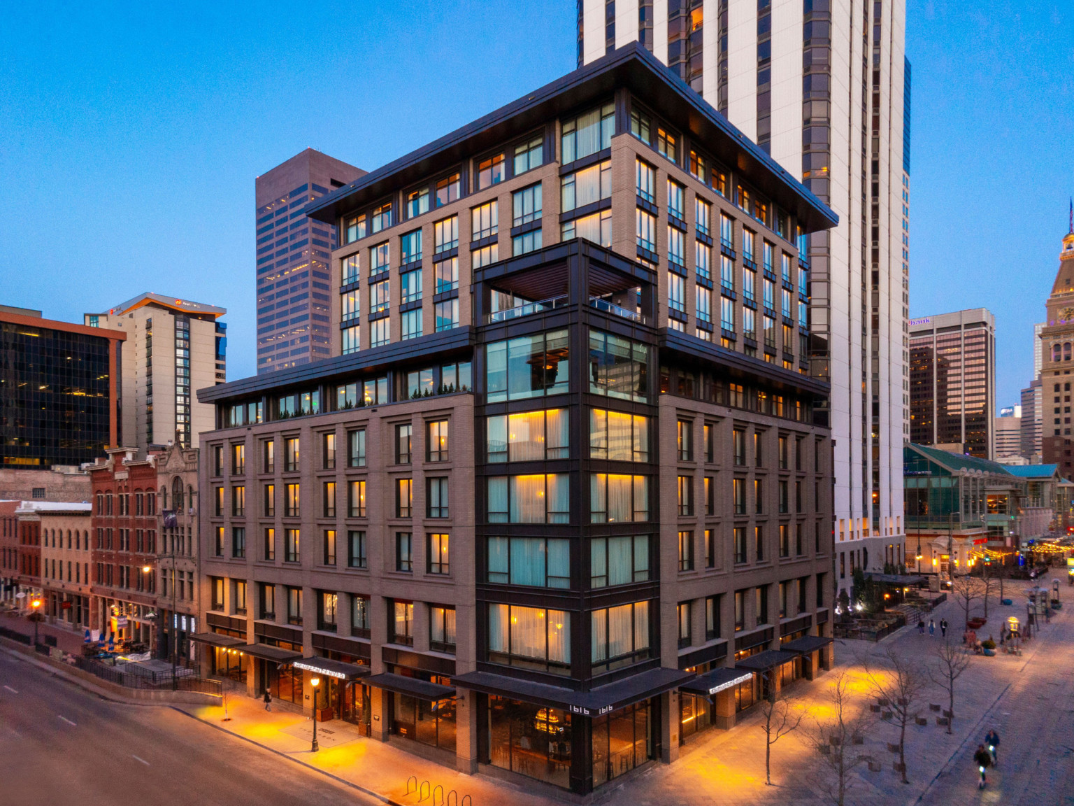 The Thompson Hotel Denver seen from corner with multitoned glass tower and stone facade on each side