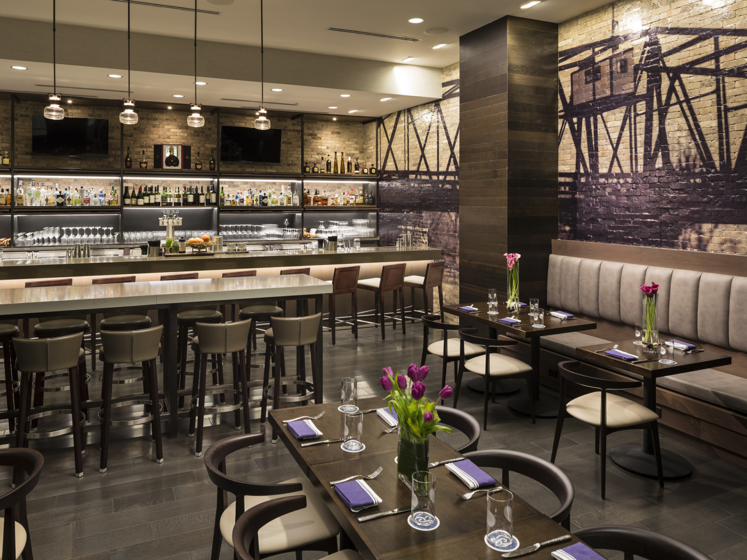 Cedar+Stone, Urban Table restaurant interior with mixed seating, mural on exposed brick wall, and hanging pendant lights Cedar+Stone, Urban Table restaurant interior with mixed seating, mural on exposed brick wall, and hanging pendant lights