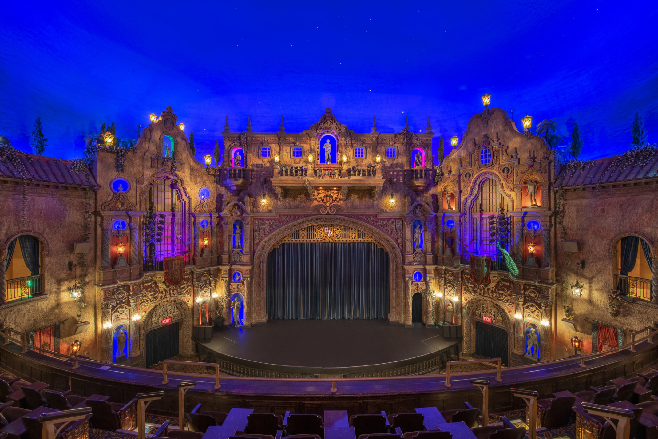 Historic Tampa Theater renovated with ornate carved proscenium with blue and orange illuminated niches with high relief sculptures