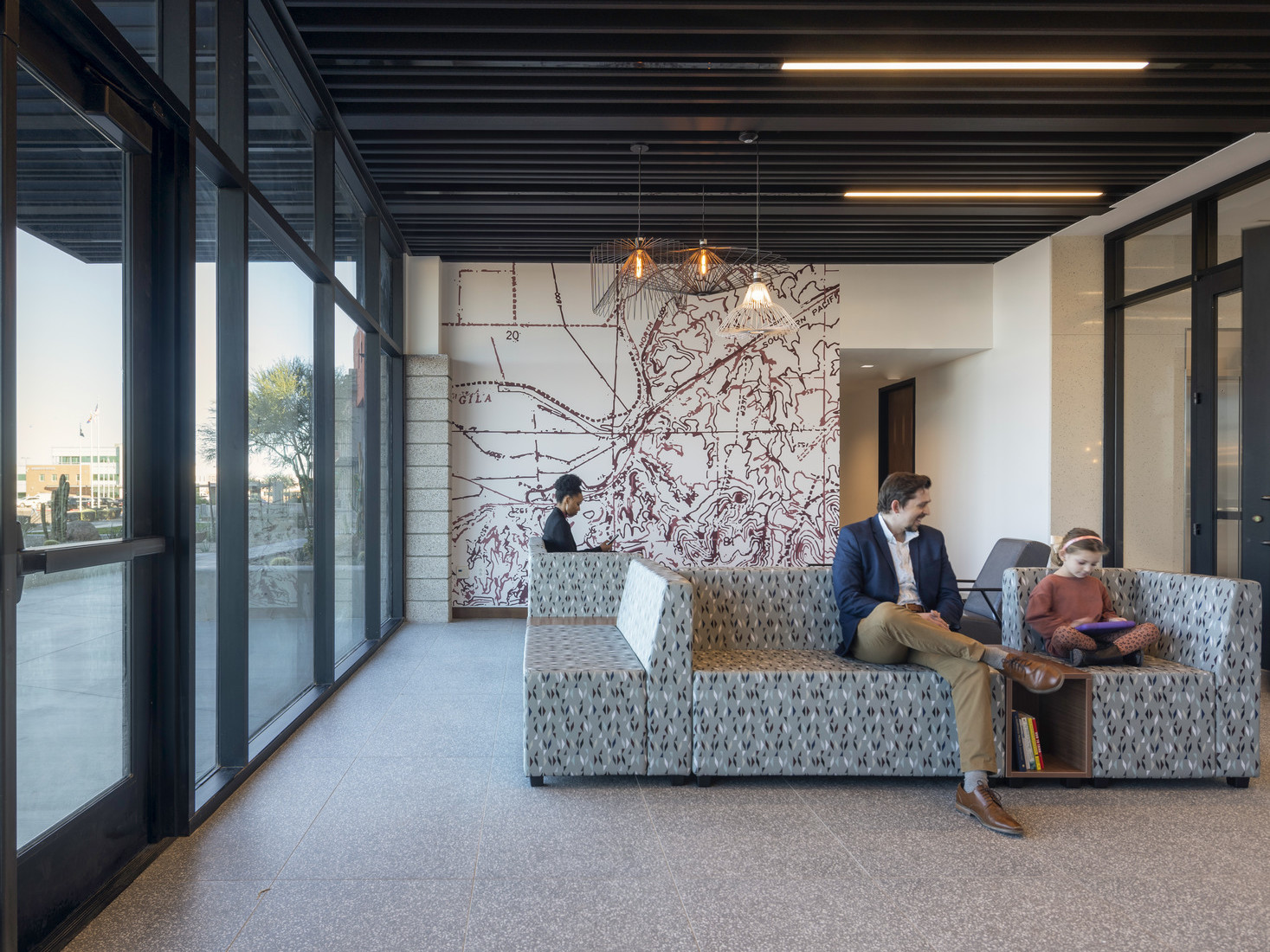 Lobby entrance with glass looking out to the desert, mural on far wall, modern wire geometric shade son pendant lights