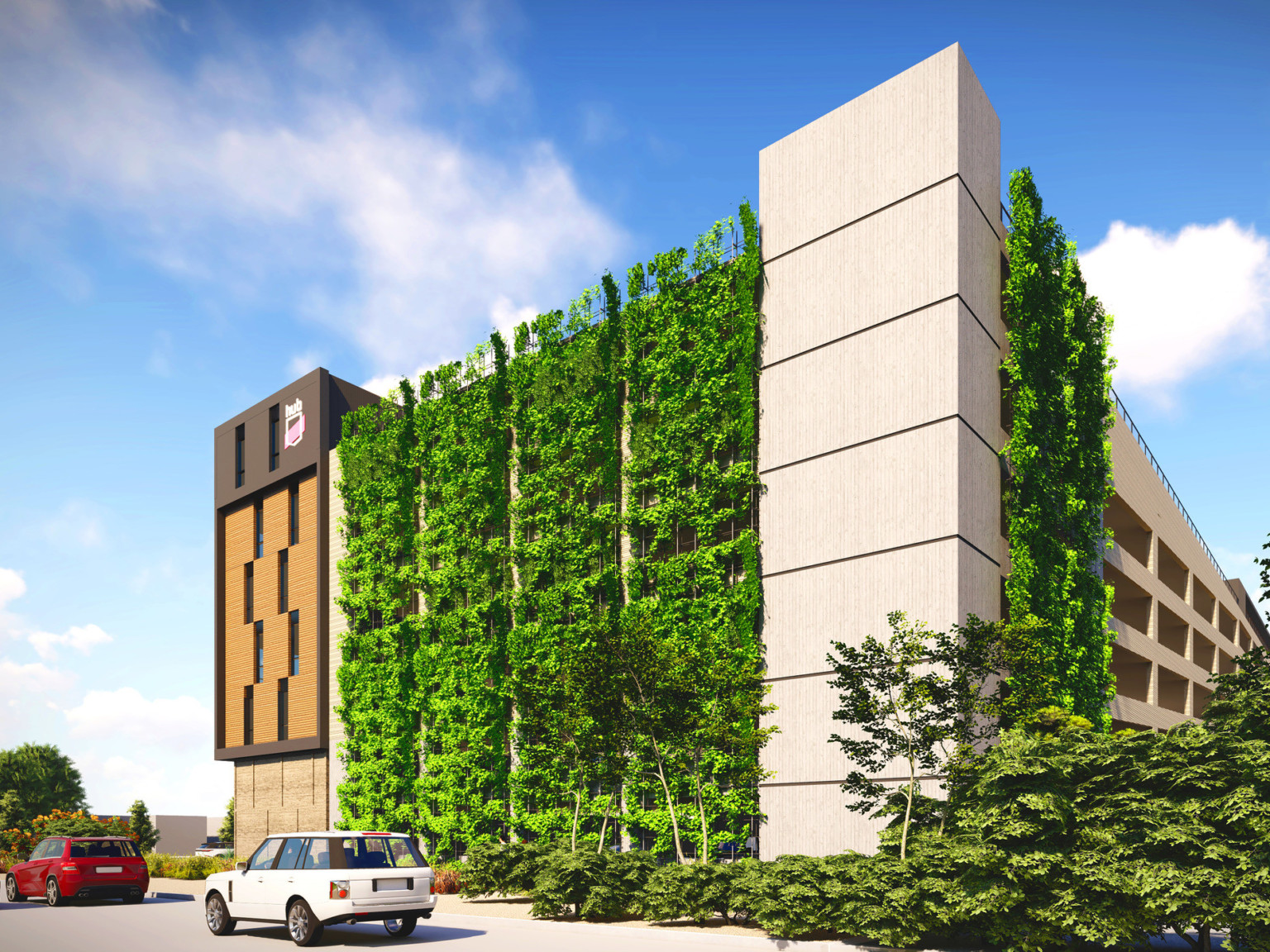 Exterior of multistory parking garage with HUB sign on left corner and green living wall along front wall and to side