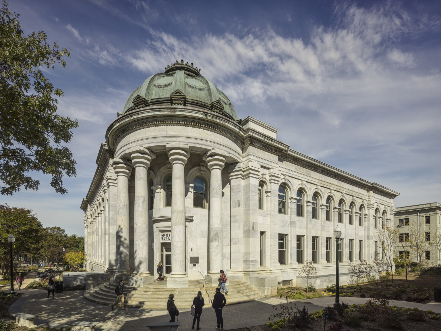 gray and white striated marble exterior columns, arched windows, cornice and green copper roof dome entrance at radius stair