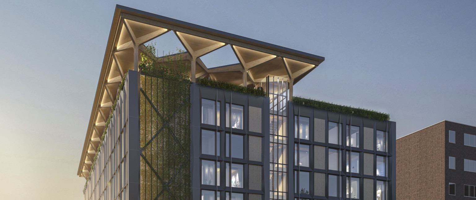 A midrise building with a blackened steel façade and timber infill with an arched timber canopy on a glassed-in rooftop A midrise building with a blackened steel façade and timber infill with an arched timber canopy on a glassed-in rooftop