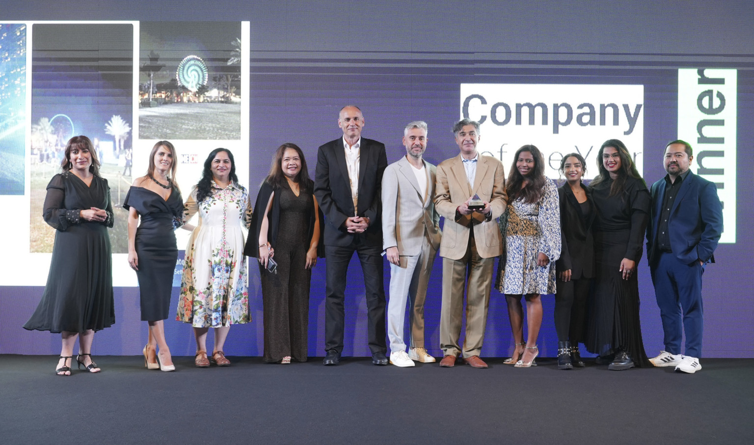 DLR Group's design team in Dubai standing next to each other after receiving the award for 2022 Company of the Year