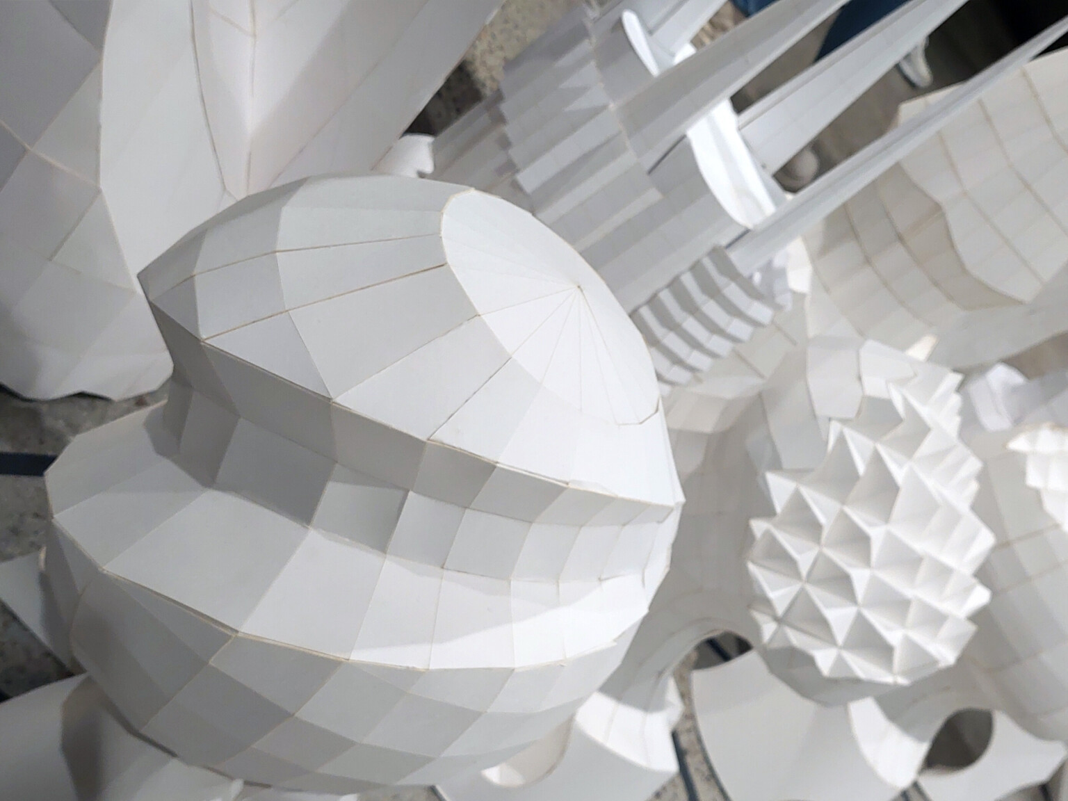 complex white shapes, spires, spheres, abstract geometries, folded grid, origami, modern art