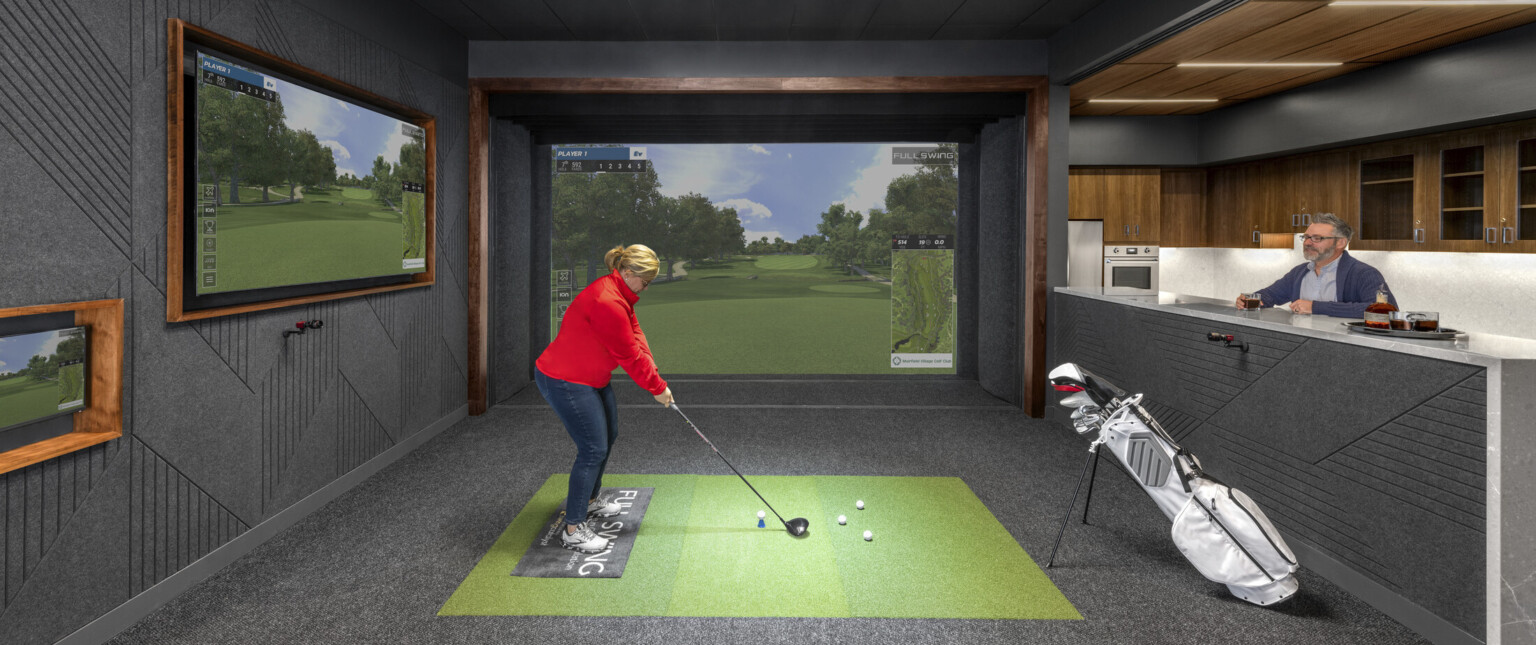 An indoor golf simulator with adjacent galley. Black room with wood accents
